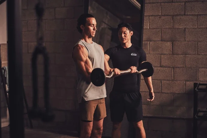 NASM trainer coaching one-to-one barbell work